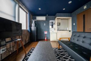 a living room with a couch and a kitchen at Silk Court 301 in Chitose
