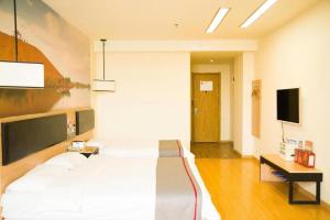 a bedroom with a large bed and a flat screen tv at Thank Inn Hotel Ningxia Yinchuan Xixia District Tongxin Road in Yinchuan