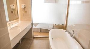 een badkamer met een ligbad en een wastafel bij GreenTree Inn Suqian Suyu District Red Star Macalline in Zhuoxu