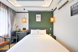 a bedroom with a bed and a desk and a chair at THE STAR HOTEL - Phú Mỹ Hưng, Hồ Chí Minh in Ho Chi Minh City