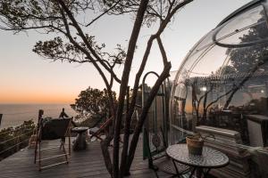 a balcony with a table and a glass house at The Ocean Dome - Misty Mountain Reserve in Thornham