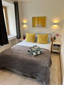 Un dormitorio con una cama grande con almohadas amarillas. en Abbaye Apartment Saint Jean D'Aulps, en Saint-Jean-dʼAulps