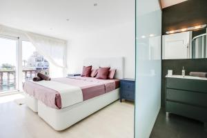 a bedroom with a large bed and a bathroom at Vista Roses Mar - Casa Pescador in Empuriabrava