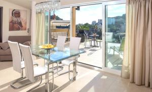 een eetkamer met een glazen tafel en witte stoelen bij Taonasi Mazzarò Apartments in Taormina