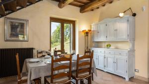 a dining room with a table and white cabinets at POGGIO DELLE LUMIE 6, Emma Villas in Arcidosso