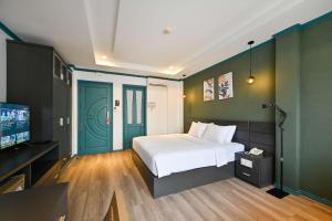 a bedroom with a bed and a flat screen tv at THE STAR HOTEL - Phú Mỹ Hưng, Hồ Chí Minh in Ho Chi Minh City