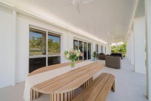 uma sala de jantar com uma mesa de madeira e bancos em Perfection in Pallarenda With Pool & Studio Apartment in Townsville em Pallarenda