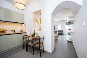 コス・タウンにあるAram's Port Houseのテーブルと椅子のあるキッチンとリビングルーム