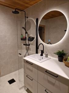 a bathroom with a sink and a shower with a mirror at Two-room apartment with sauna in the Old Town in Savonlinna