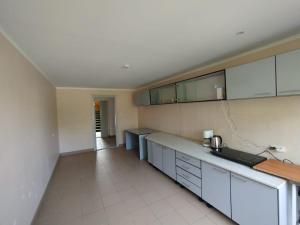 a kitchen with white cabinets and a counter top at Skrunda Park in Skrunda