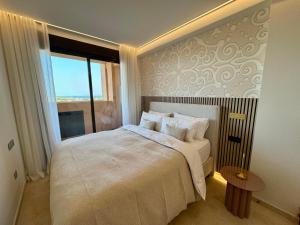 a bedroom with a large bed and a window at M&M La Cala Suite in La Cala de Mijas