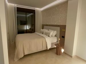 a bedroom with a white bed and a window at M&M La Cala Suite in La Cala de Mijas