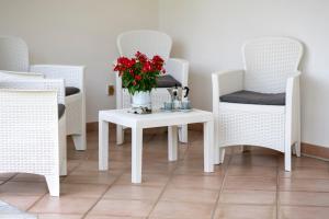 a table with a vase of flowers on it with chairs at A Casa da Carol in Montecorice