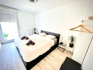 a bedroom with a large bed with white sheets at New apartment near Paris in Bezons