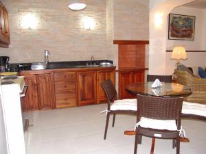 cocina con mesa, sillas y fregadero en La Posada Del Aromito - Apartment, en Cumbayá
