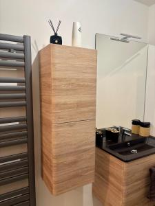 a wooden cabinet with a sink in a room at New apartment near Paris in Bezons +56 photos