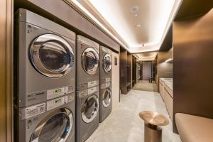 a row of washing machines in a laundry room at Orange Crystal Qingdao Taitung Pedestrian Street Hotel in Qingdao