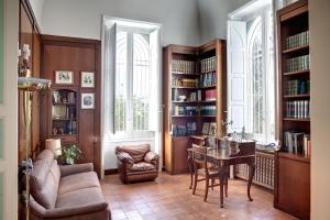 a living room with a table and a chair and book shelves at La Serra - Villa De Bonis in San Cesario di Lecce