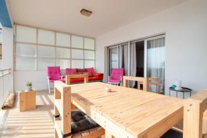 a living room with a wooden table and pink chairs at Claudius Mare in Gandía