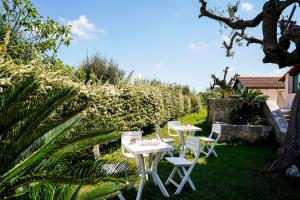 a row of tables and chairs in a garden at Villa Dragonfly by BarbarHouse in Castellana Grotte
