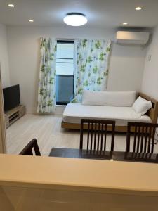a living room with a bed and a table with chairs at Tokyo Link House Halona-Direct to Shinjuku, Shibuya, Ginza in Tokyo