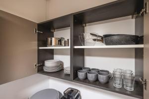 einem Schrank mit Tellern, Tassen und Geschirr darin in der Unterkunft Appartamento Sagittario in Misano Adriatico