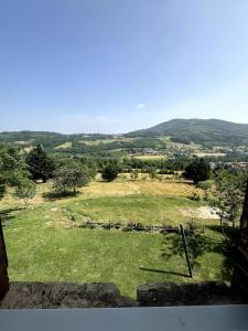 a view of a field of grass with mountains in the background at Gite à la ferme, Domaine Solio in Satillieu