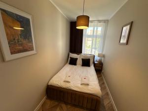 a small bedroom with a bed with two pillows at Apartment Chorzow Center in Chorzów