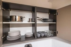 ein Küchenschrank mit Tellern und Geschirr darin in der Unterkunft Appartamento Sagittario in Misano Adriatico + 41 Fotos
