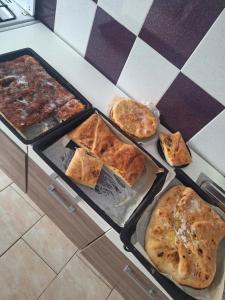 a table with three trays of different types of pizzas at Casa Maria in Costeşti