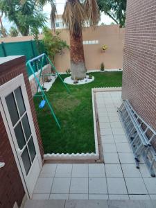 a small yard with a tree and a swing at El Chalét de Manolo in Aljaraque