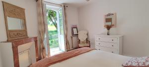 a bedroom with a bed and a fireplace and a window at Le Petit Clos - Village house in Saint-Geniès in Saint-Geniès