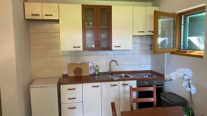 a small kitchen with white cabinets and a sink at Villa Maslinica in Maslinica +88 photos
