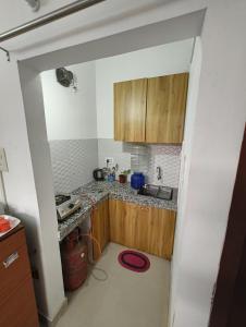 una piccola cucina con armadi in legno e lavandino di The Samay Inn ,Jalukbari a Guwahati