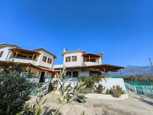 a house on the beach with mountains in the background at Villa Paradies in Káto Lekhónia