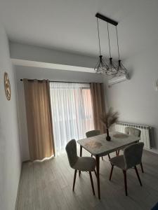 einen Esstisch und Stühle in einem Zimmer in der Unterkunft Blue Apartment in Năvodari + 11 Fotos