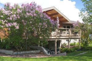 une maison avec un arbre et des fleurs violettes dans l'établissement Windermere Lakeside Bed and Breakfast, à Windermere