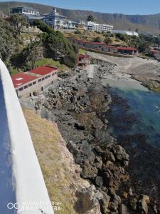 赫曼努斯Seashell Cottage的悬崖上靠近水体的建筑物