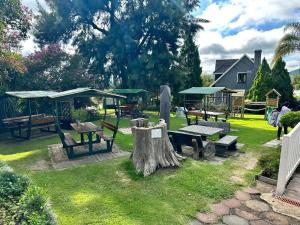 a park with benches and picnic tables and a tree stump at Thyme and Again B&B Estcourt in Estcourt