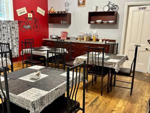 a dining room with tables and chairs and a red wall at Thyme and Again B&B Estcourt in Estcourt