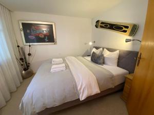 Un dormitorio con una gran cama blanca con radio. en Rothornblick 28 by Arosa Holiday, en Arosa