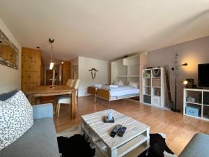 Una sala de estar con una cama, un sofá y una mesa. en Rothornblick 28 by Arosa Holiday, en Arosa