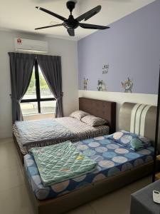 a bedroom with two beds and a ceiling fan at KH Water Park Manhattan Condo Ipoh Homestay in Kampong Pinji +38 photos