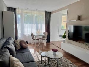 a living room with a couch and a tv and a table at SORD apartment in Liepāja