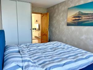 a bedroom with a bed with a painting on the wall at SORD apartment in Liepāja