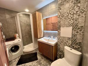 a bathroom with a toilet sink and a washing machine at SORD apartment in Liepāja +8 photos