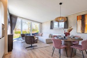 un soggiorno con un divano, un tavolo e delle sedie di De Leughte Resort Renswoude a Renswoude
