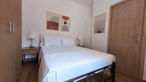 a bedroom with a white bed and a wooden door at Filio's House in Samothraki