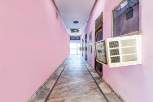 a corridor of a room with pink walls at Hotel O Muchhad 75 Hotel & Restaurant in Etāwah