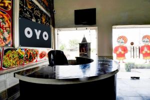 a bar in a restaurant with paintings on the wall at Hotel O Muchhad 75 Hotel & Restaurant in Etāwah